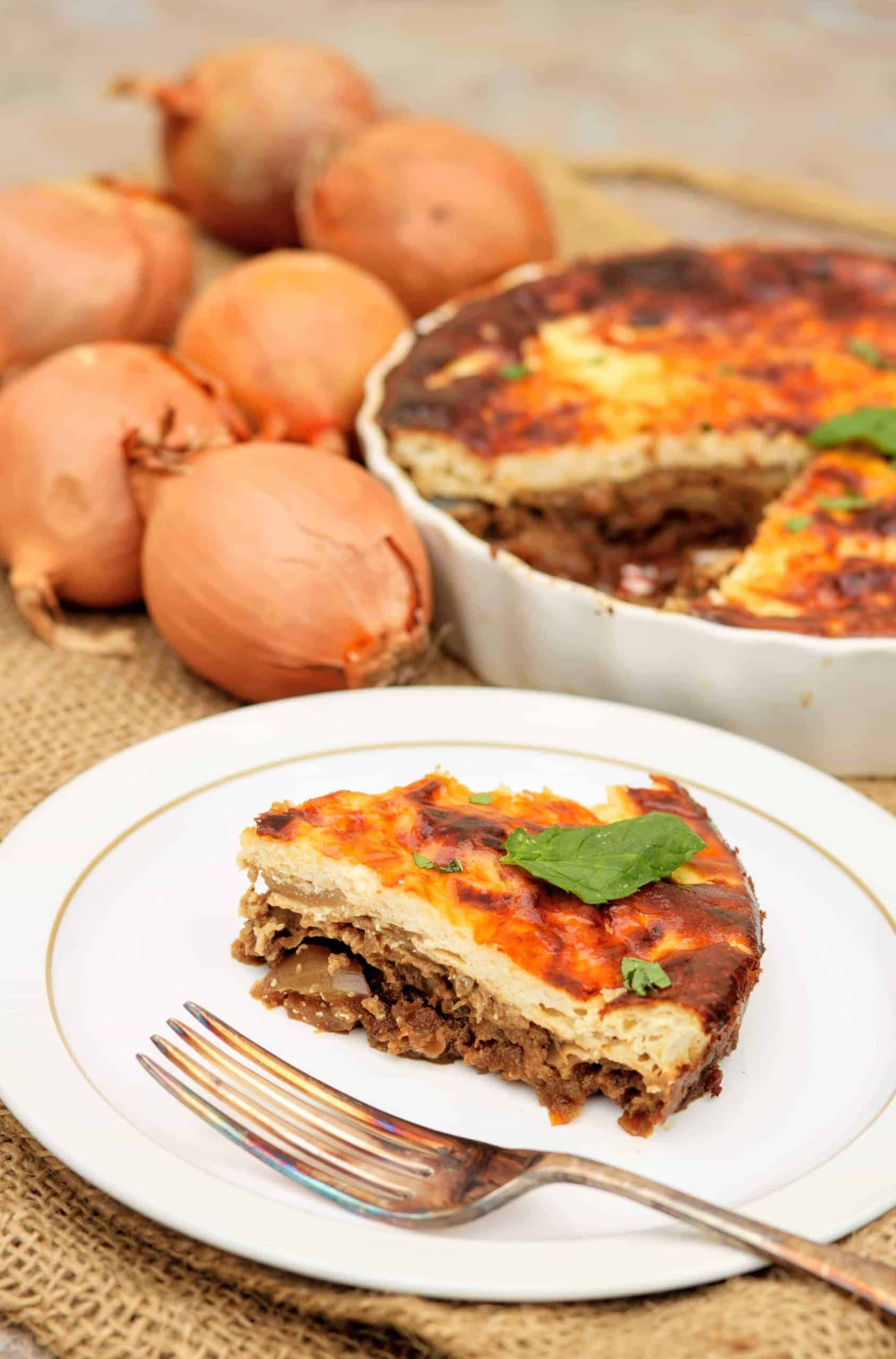 A slice of cheese and onion tart on a white Denby plate