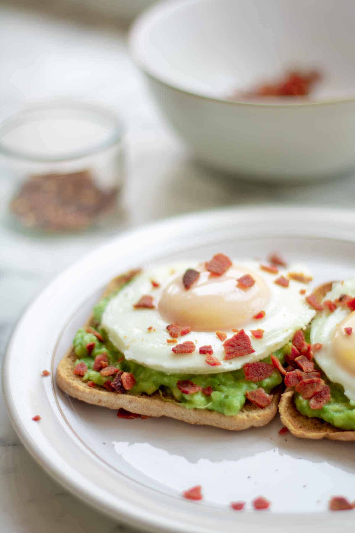 poached egg on avocado on toast on white plate