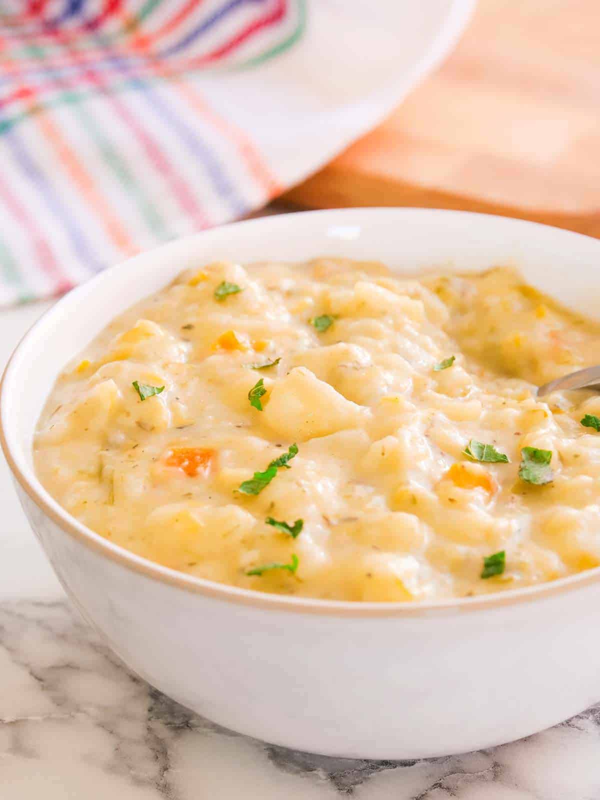 Close up of chunky and creamy potato and carrot soup in a white Denby Natural Canvas bowl
