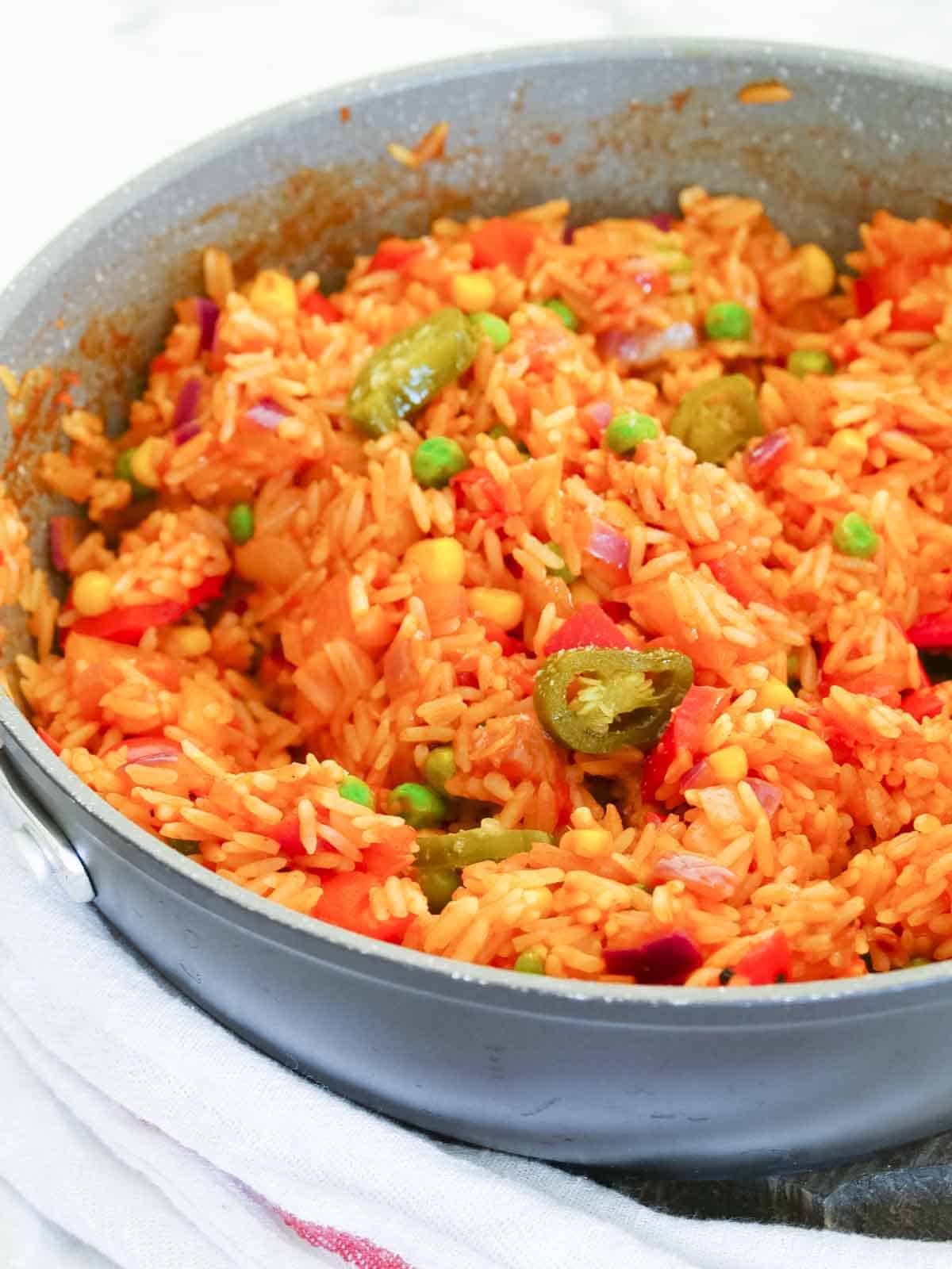 Jalapenos added to spicy Mexican rice in frying pan