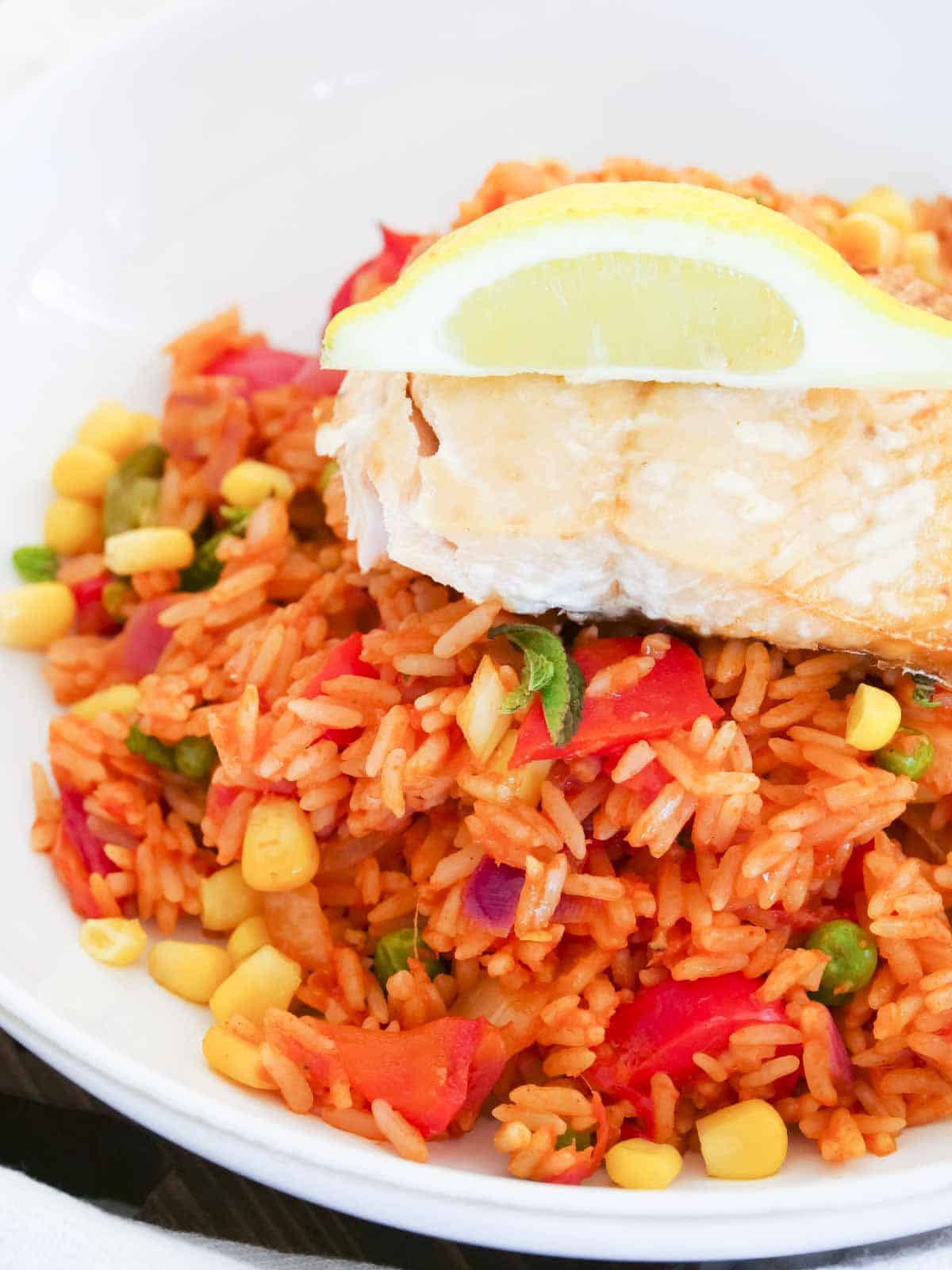 roasted salmon and lemon served on top of Mexican red rice.