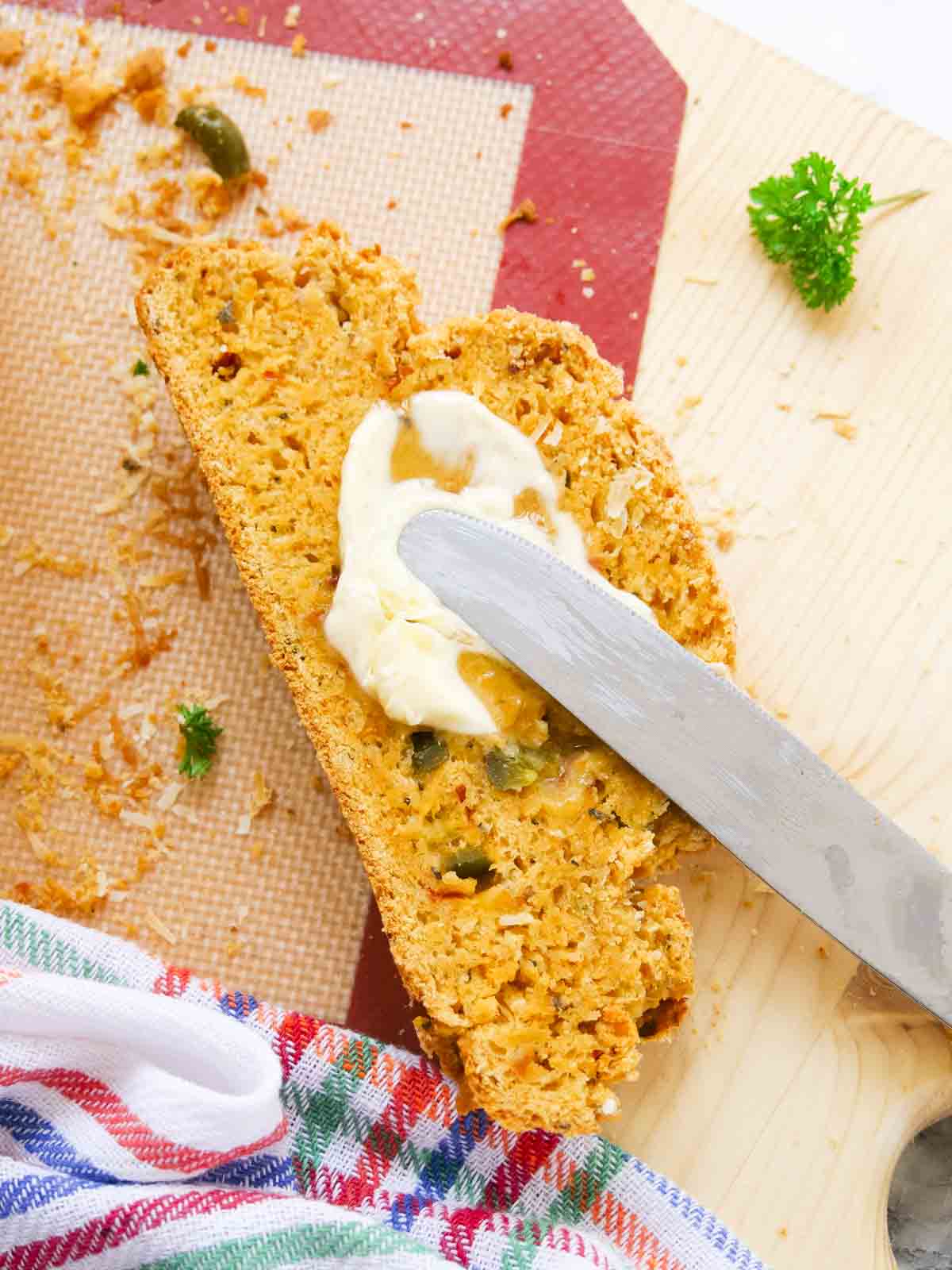 spreading butter on a freshly baked slice of damper bread with cheese