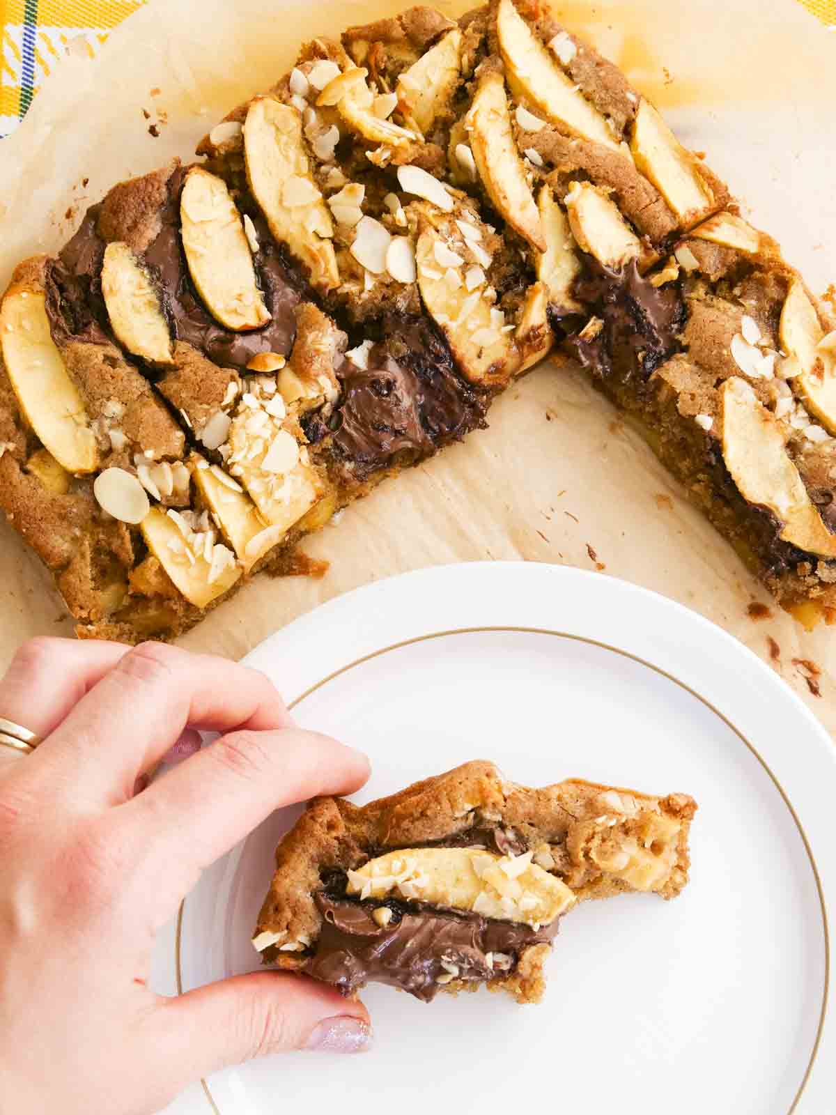 Biting a slice of apple chocolate cake with cinnamon