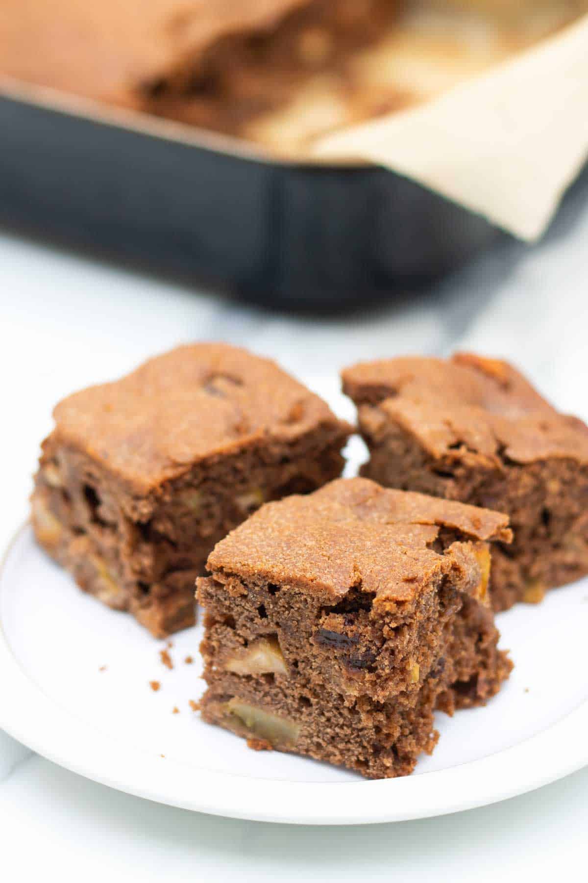 3 pieces of dutch apple cake squares with raisins on a white plate