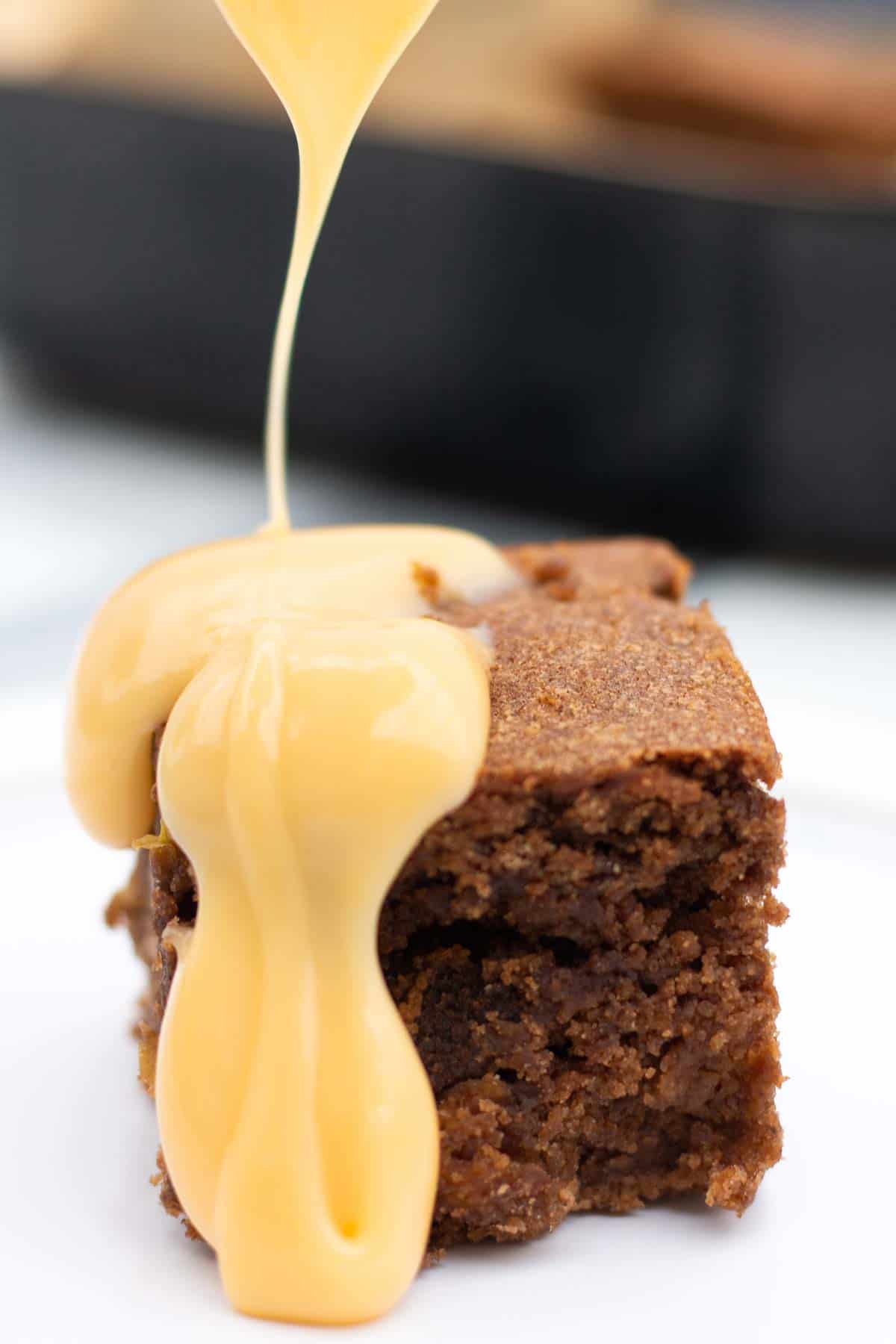Pouring over custard on apple and raisin pudding
