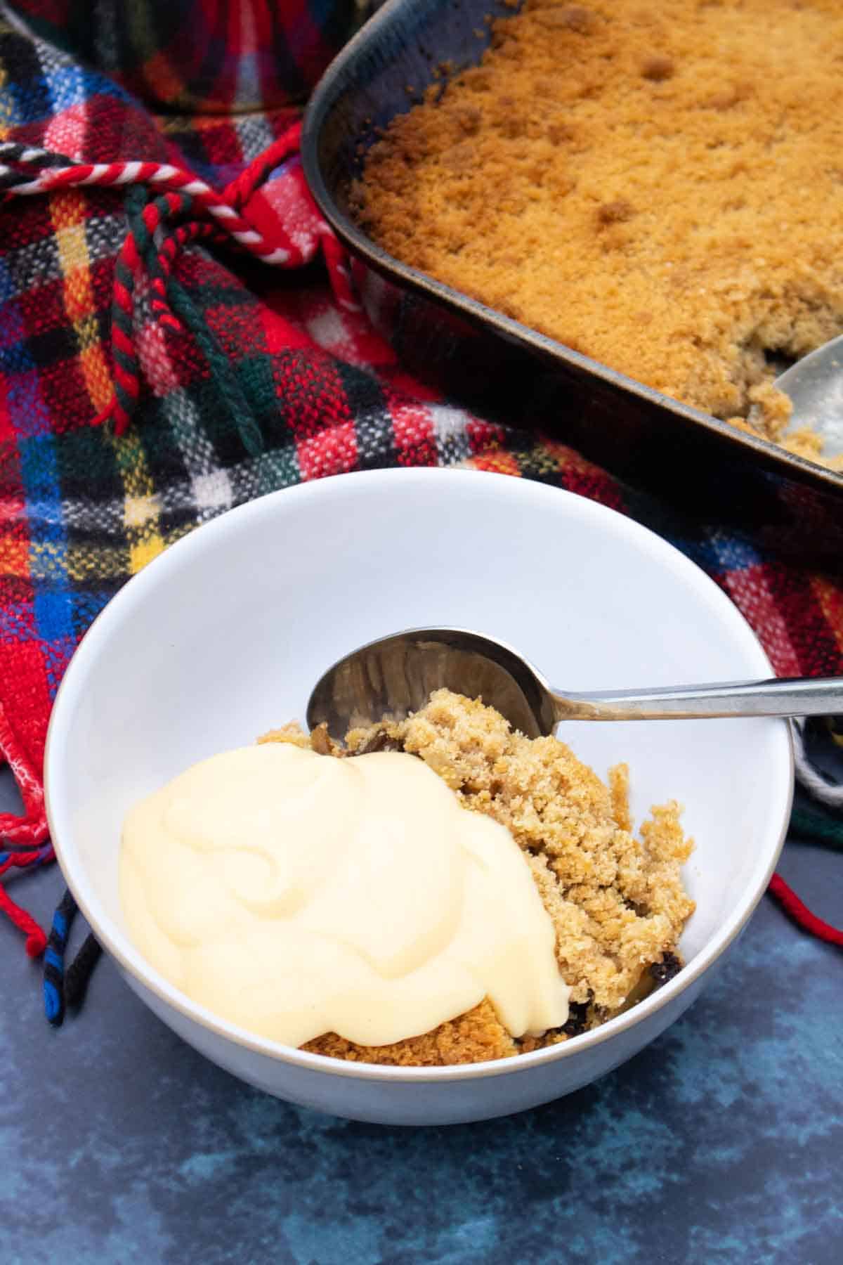 A bowl of apple crumble and custard