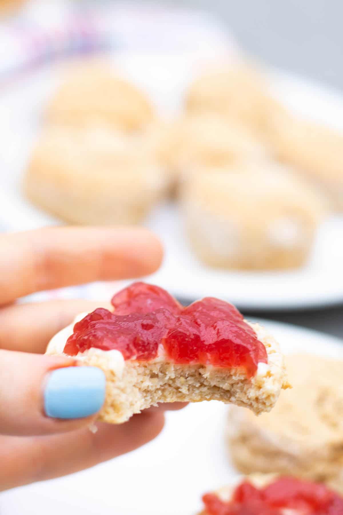Biting a healthy jam and butter scone without clotted cream