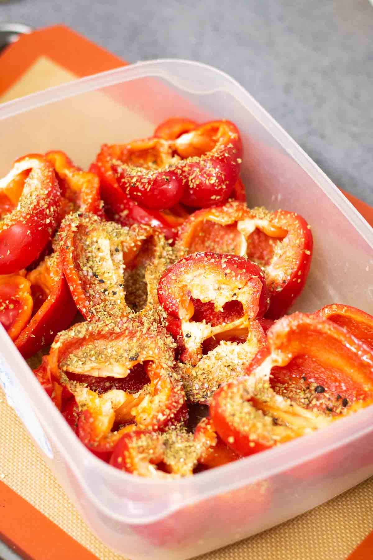 Coating red peppers in oil, seasoning and herbs before making roast pepper soup