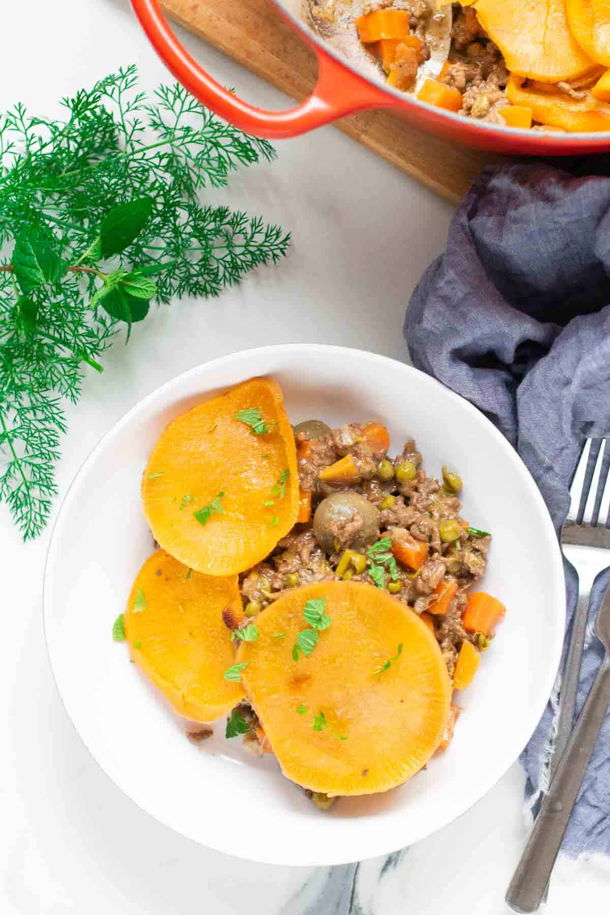 Birdseye view of stew minced beef and swede slices in a white Denby bowl