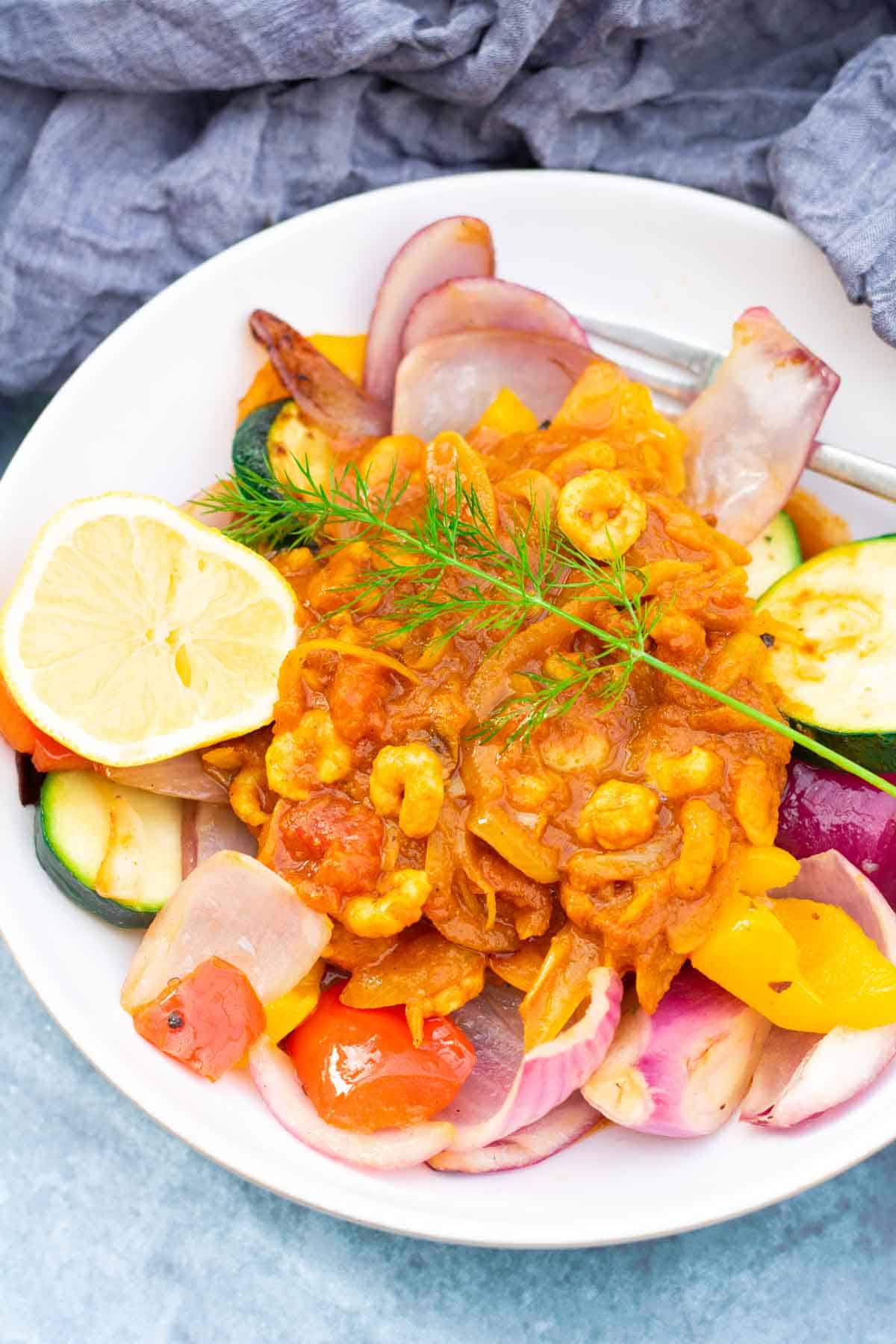 Close up of a quick and easy prawn bhuna with vegetables in a large white bowl