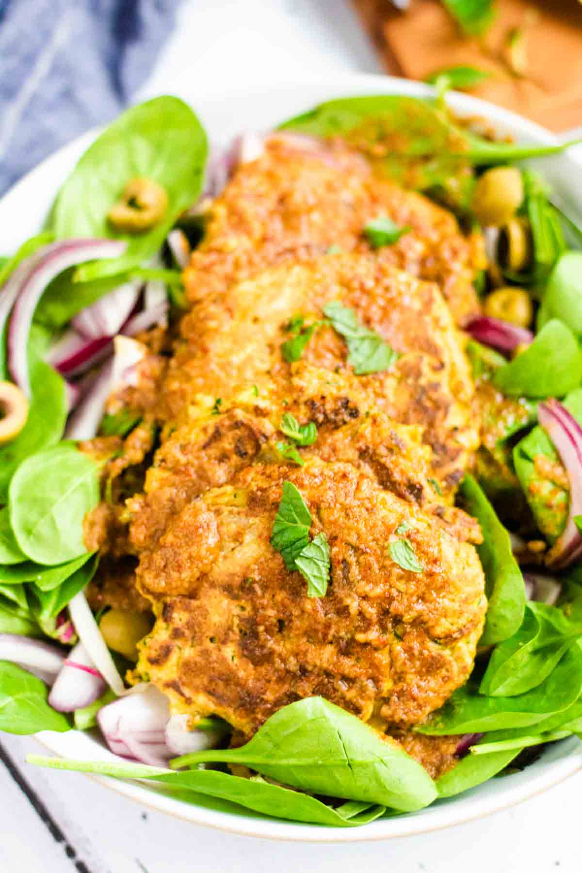 Quick peanut satay sauce with lime juice drizzled on shrimp fritters for a prawn salad