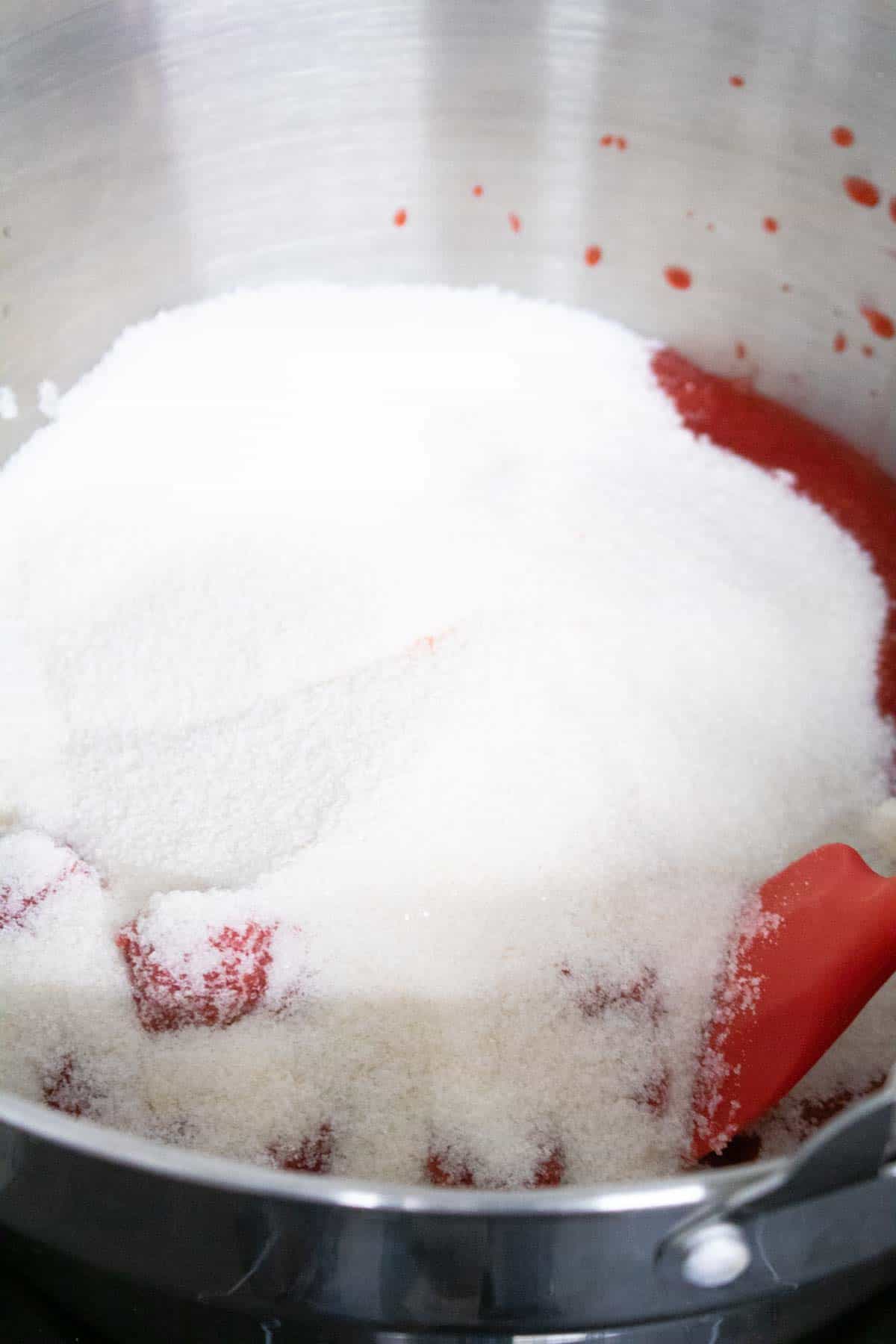 Jam sugar in a jam pan on top of raspberries, blueberries and lemon juice
