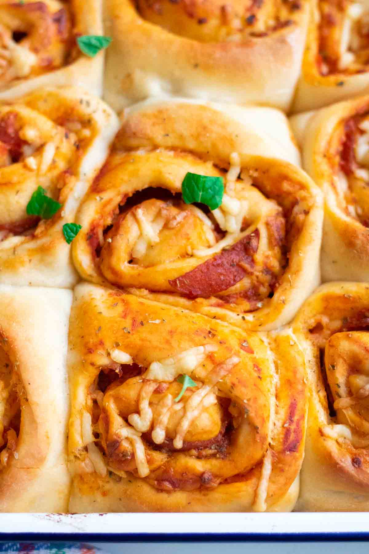 Close up of pizza swirls proofed close together with pepperoni