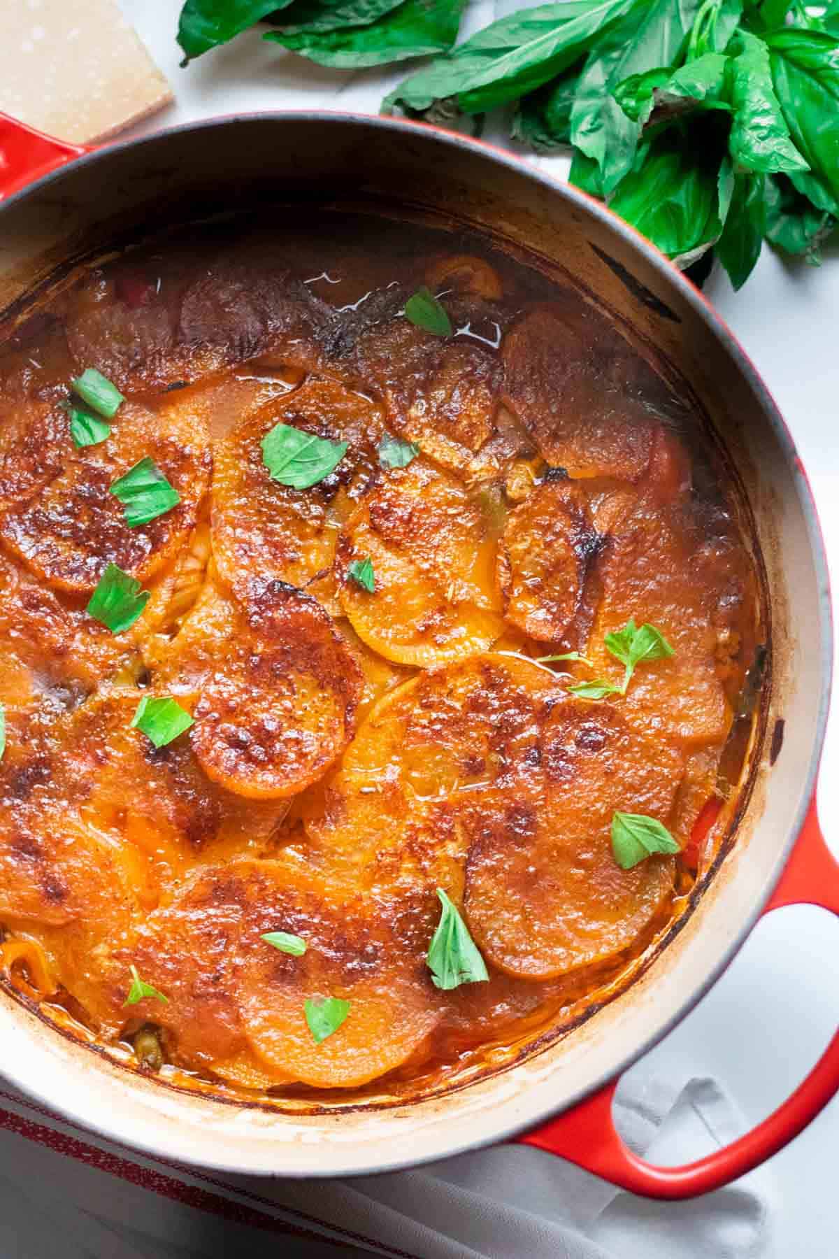 Close up of oven baked parmigana reggiano and torn fresh basil on swede or turnip on lamb casserole