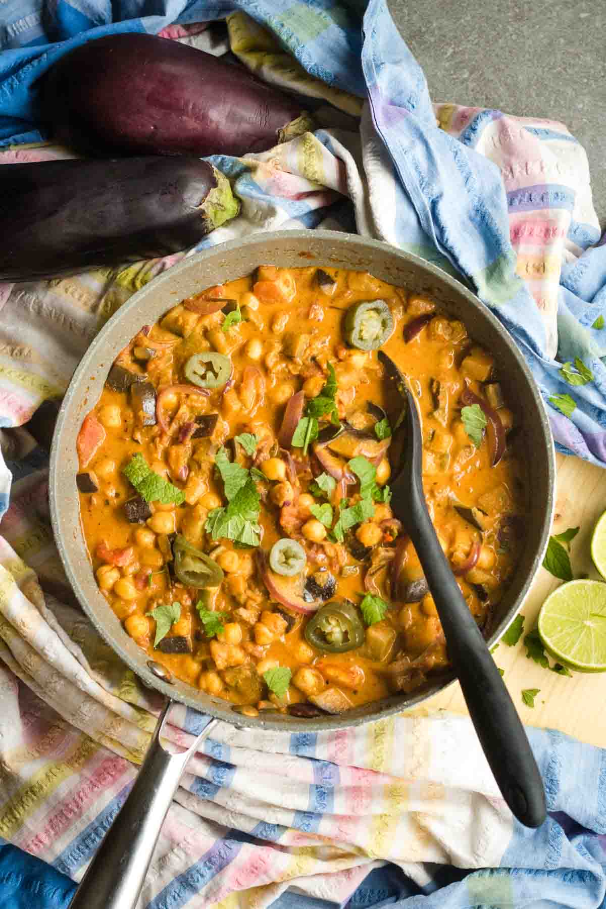 Recipe for aubergine curry in a pan on a table ready to serve