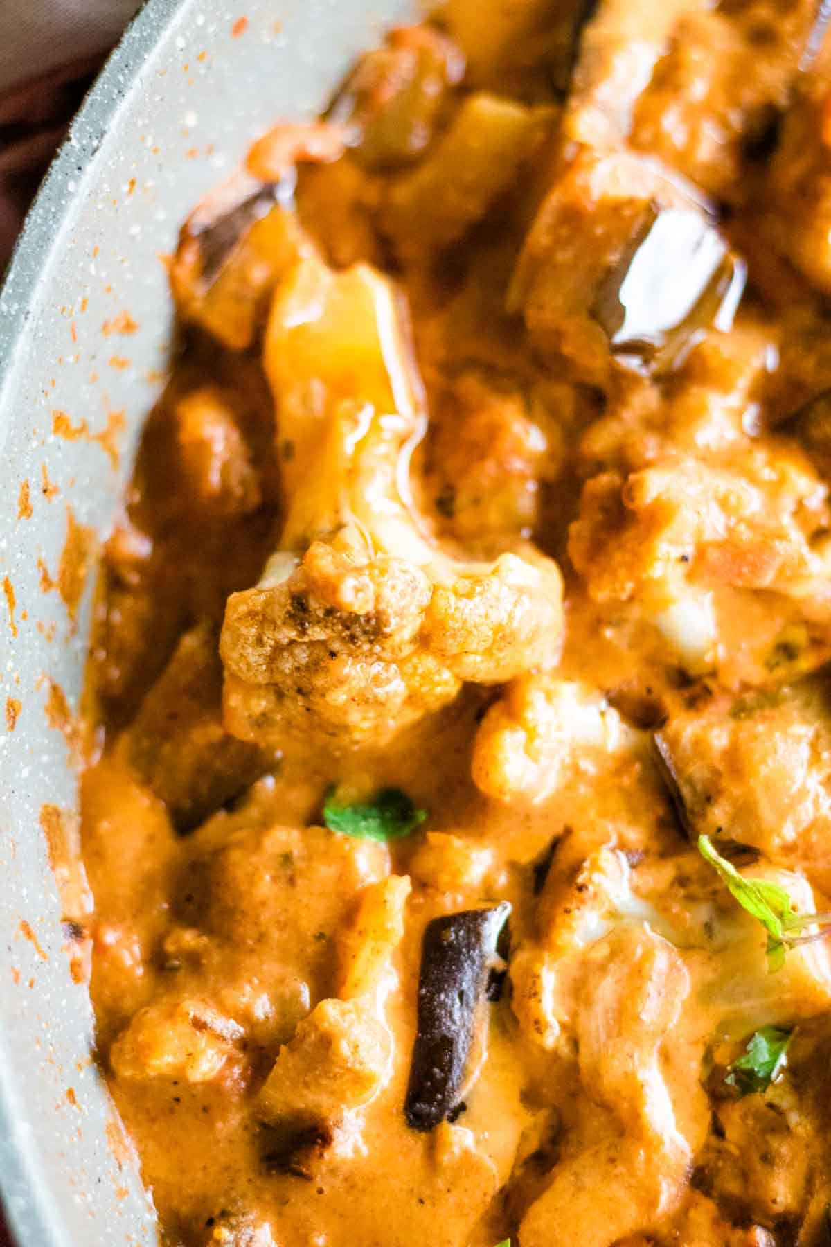 Close up of cauliflower florets cooked in a Thai vegan tomato curry sauce
