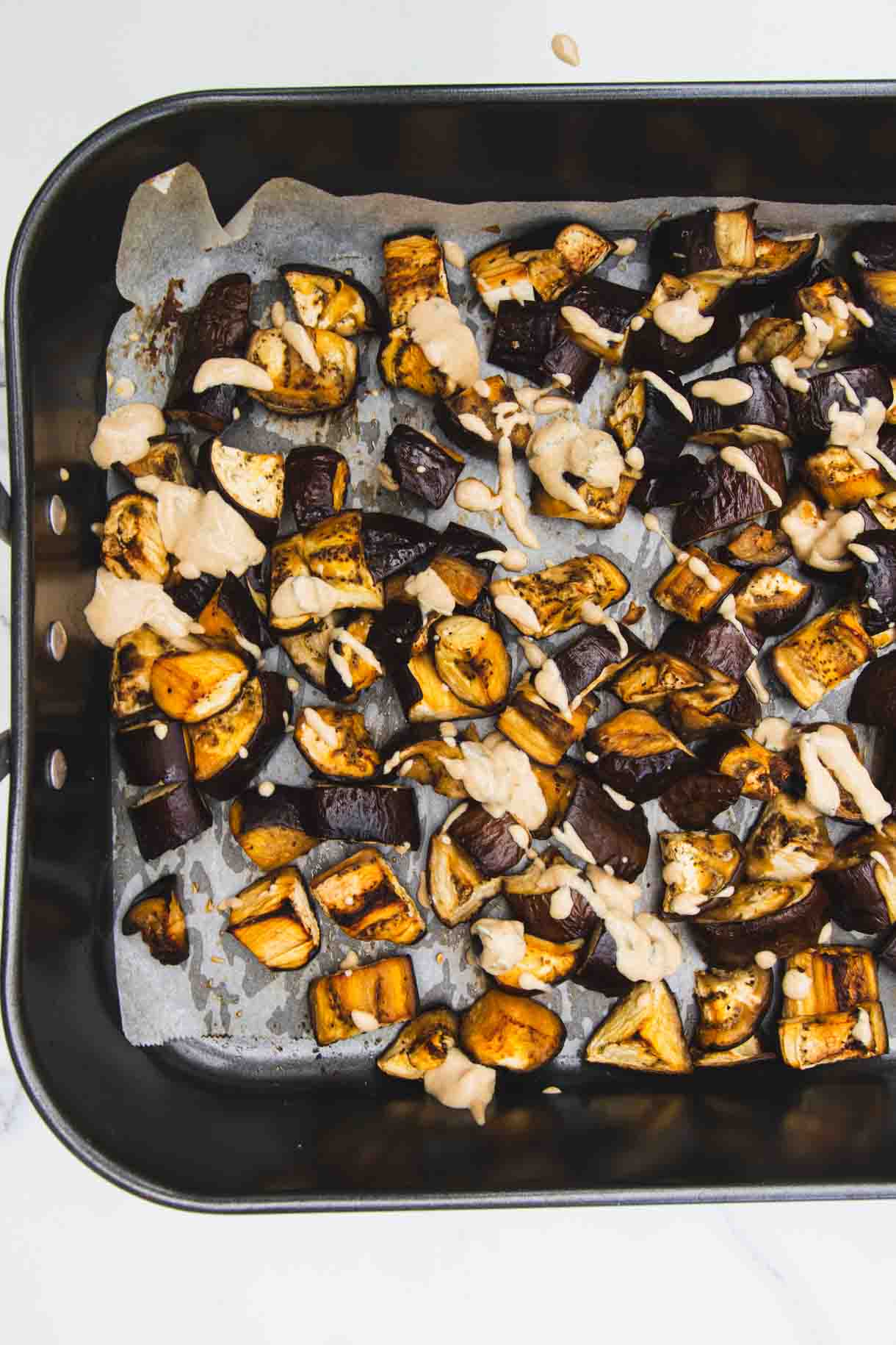 Close up of baked aubergine with tahini sour cream