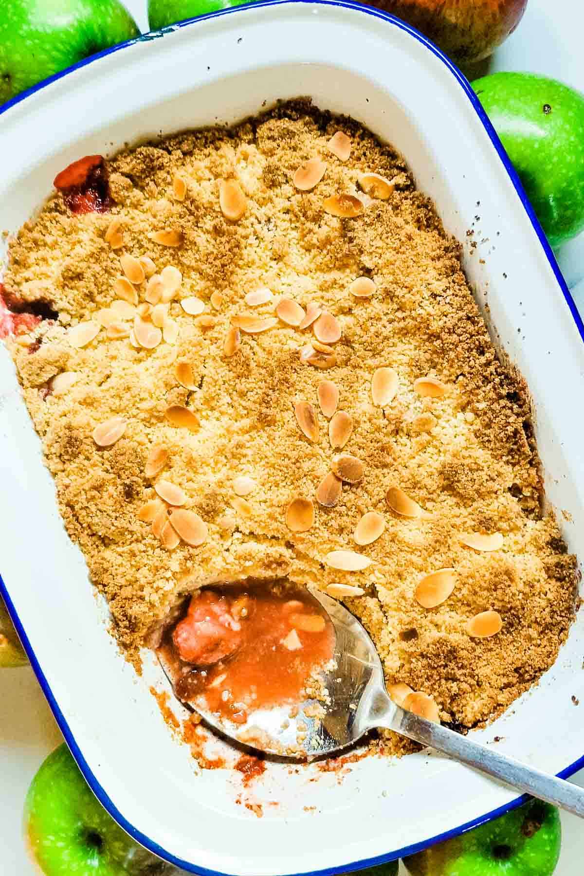 Baked apple cinnamon crumble with stawberries in a large white baking dish