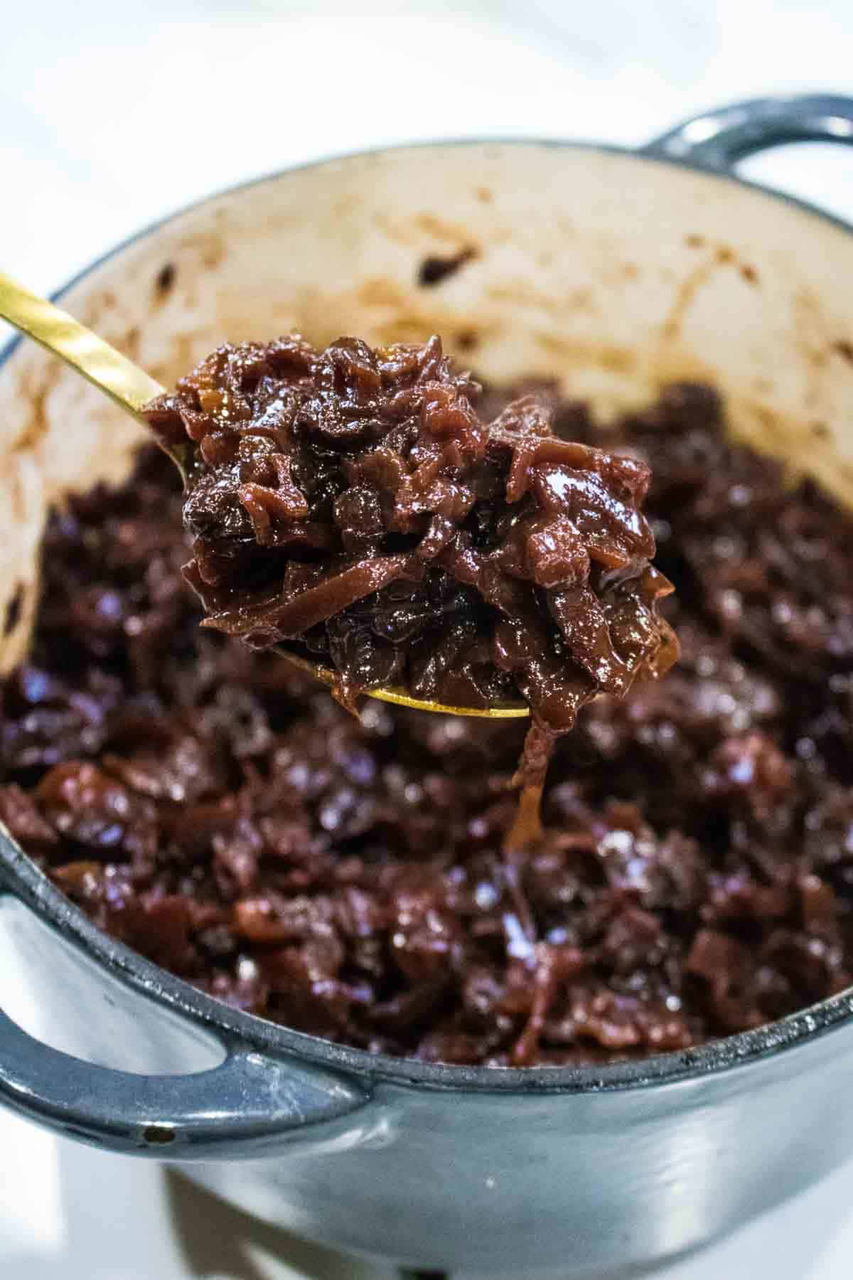 ladle full of Christmas slow cooked red cabbage spooned from a cast iron dish cooked on a multi fuel stove