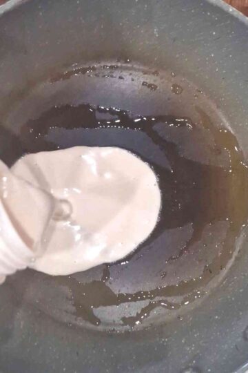 Pouring pancake batter onto a frying pan