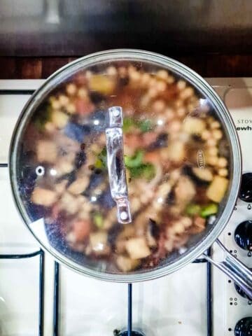 food being cooked in a lidded pot on the hob
