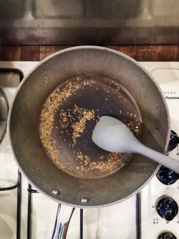 dry frying spices in a frying pan