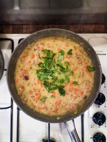 fresh cilantro in a pan of carrot lentil soup recipe