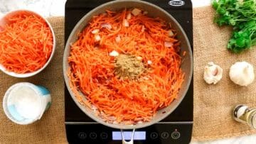 frying grated carrots, diced potatoes and ground coriander in a large pot