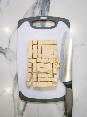 tofu cut into cubes on a chopping board