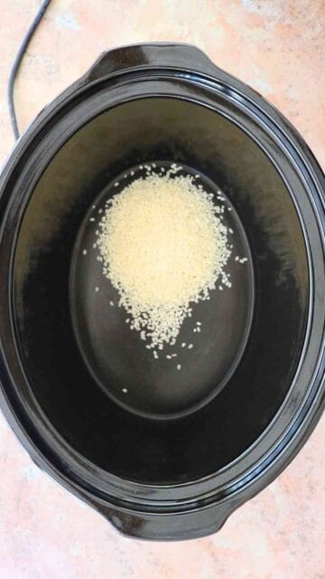 uncooked pudding rice placed in a slow cooker