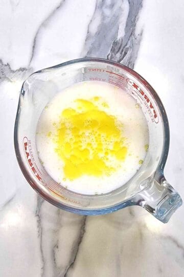 Milk and orange essence with aquafaba in a Pyrex mixing jug