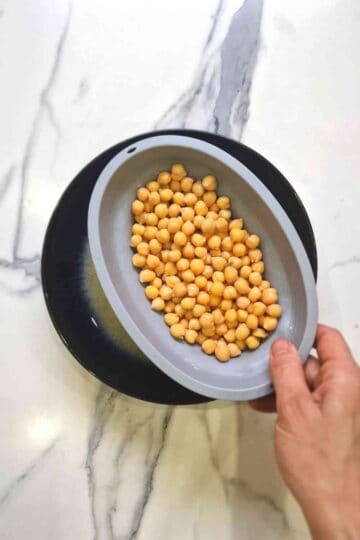 chickpeas being drained in a colander for aquafaba