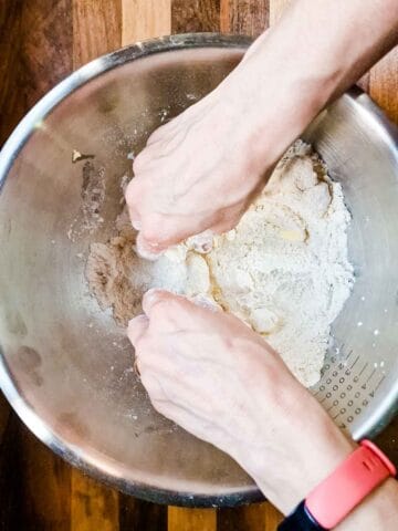person rubbing butter and flour together to make fine breadcrumbs