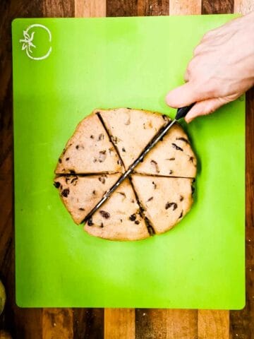 person cutting 6 wedges to evenly divide fat rascal dough