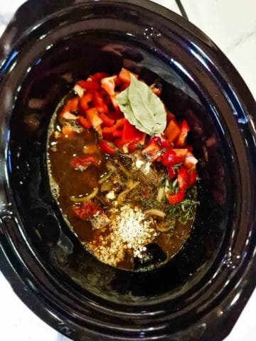 braised steak and onion ingredients all in a crock pot with vegetables