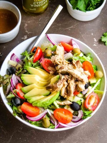 mediterranean salad served into a large bowl with drained mackerel on top