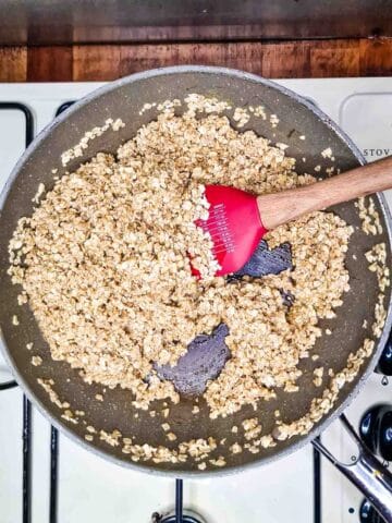 oats being stirred into a butter and syrup mixture