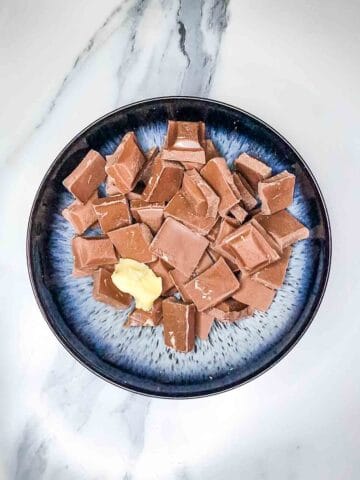 broken chocolate and butter in a microwavable bowl before being melted in the microwave