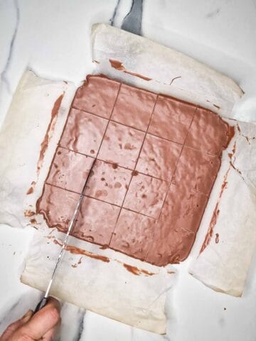 person scoring chocolate into 16 flapjacks before cutting completely