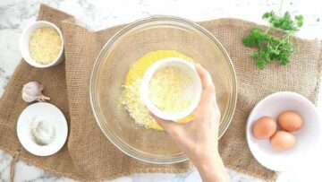 person maxing grated cheese with egg and seasoning for a carbonara sauce