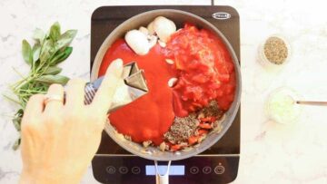 pouring in passata to make a healthy low fat beefy bolognese sauce