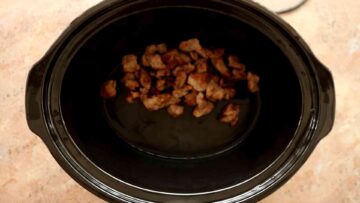 browned beef chunks in a slow cooker