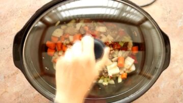 person placing a lid on top of a slow cooker before cooking long and slow