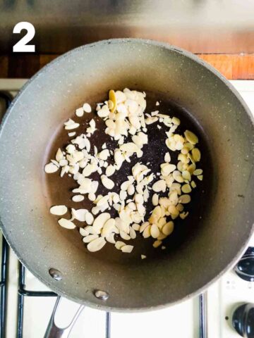 almond flakes being toasted in a dry frying pan on hob