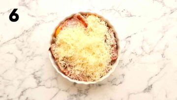 grated cheese on top bacon and egg in quiche dish