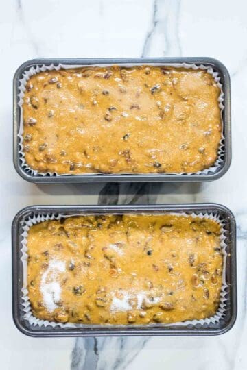 fruit loaf cake mixture poured into lined 2 lb loaf pans, the granulated sugar sprinkled on top before baking