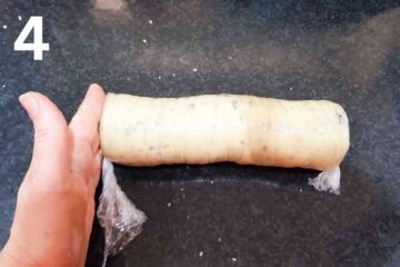 person patting the ends of a wrapped cookie dough
