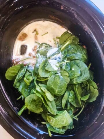 coconut milk, spinach and lemon juice in a slow cooked sausage curry before stirring