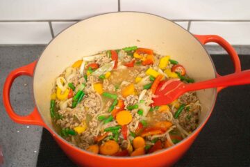 vgetables, stock, tomato puree and lamb in a cast iron dish to make a hotpot on the stove