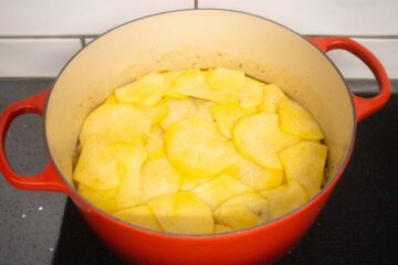 slices of swede on a lamb hotpot before cooking in the oven